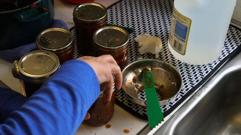 5 jars being filled with chili